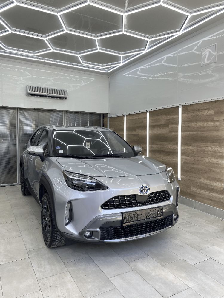 Сребриста Toyota Yaris Cross в студиото под шестоъгълно LED осветление